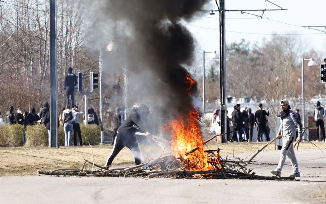 Protesters building a burning barricade on a street during unrest in Norrkoping, Sweden on Sunday.