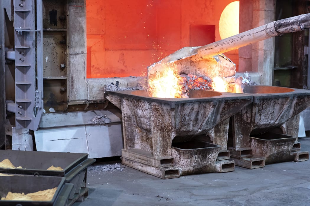 Skimming melted aluminum for removing the dross before casting.