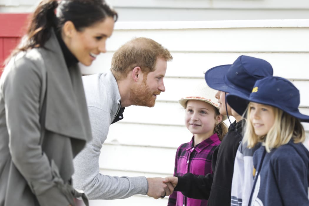 Prince Harry and Meghan talk to some schoolchildren outside Maranui Cafe.