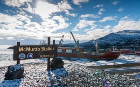 Jan 02, 2019: McMurdo Station Antarctica sign with cargo ship unloading
