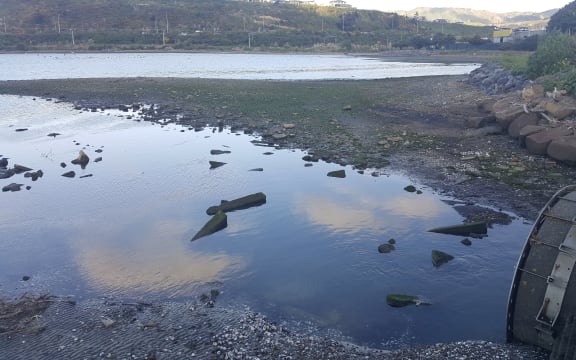 Urukahika Stream arrives in the Onepoto arm of Porirua Harbour via a pipe (right). State Highway 1 and the main trunk railway run alongside the far side of the harbour.