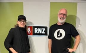 Trevor Reekie and Joost Langeveld pose in front of the RNZ sign at RNZ Auckland