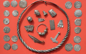 Some of the silver treasures from Schaprode, including a coiled ring, silver beads, cut-up silver jewellery, Thor's hammer amulet, and Danish and Ottonian coins.