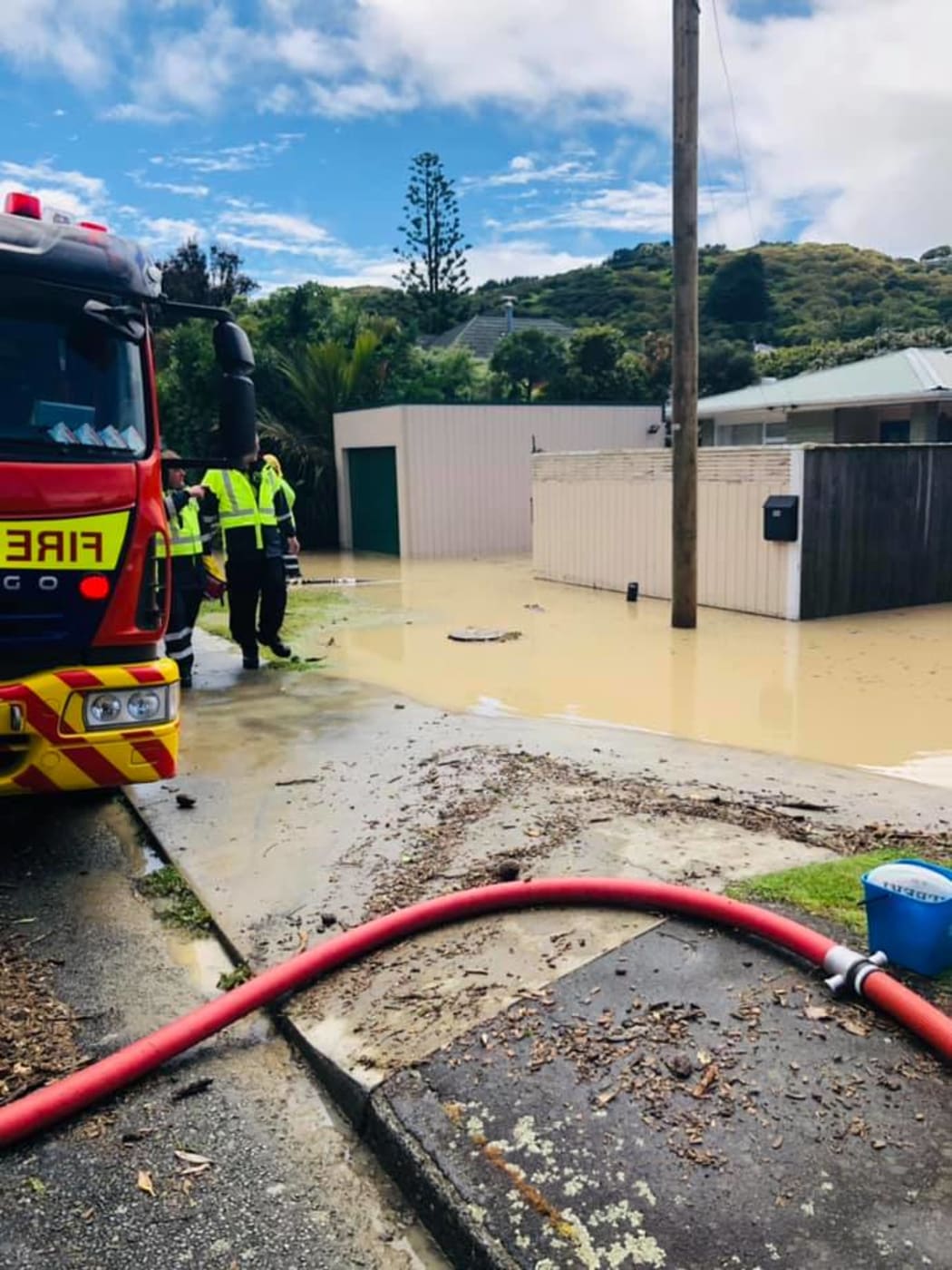 Fire fighters trying to pump water from a Plimmerton home.