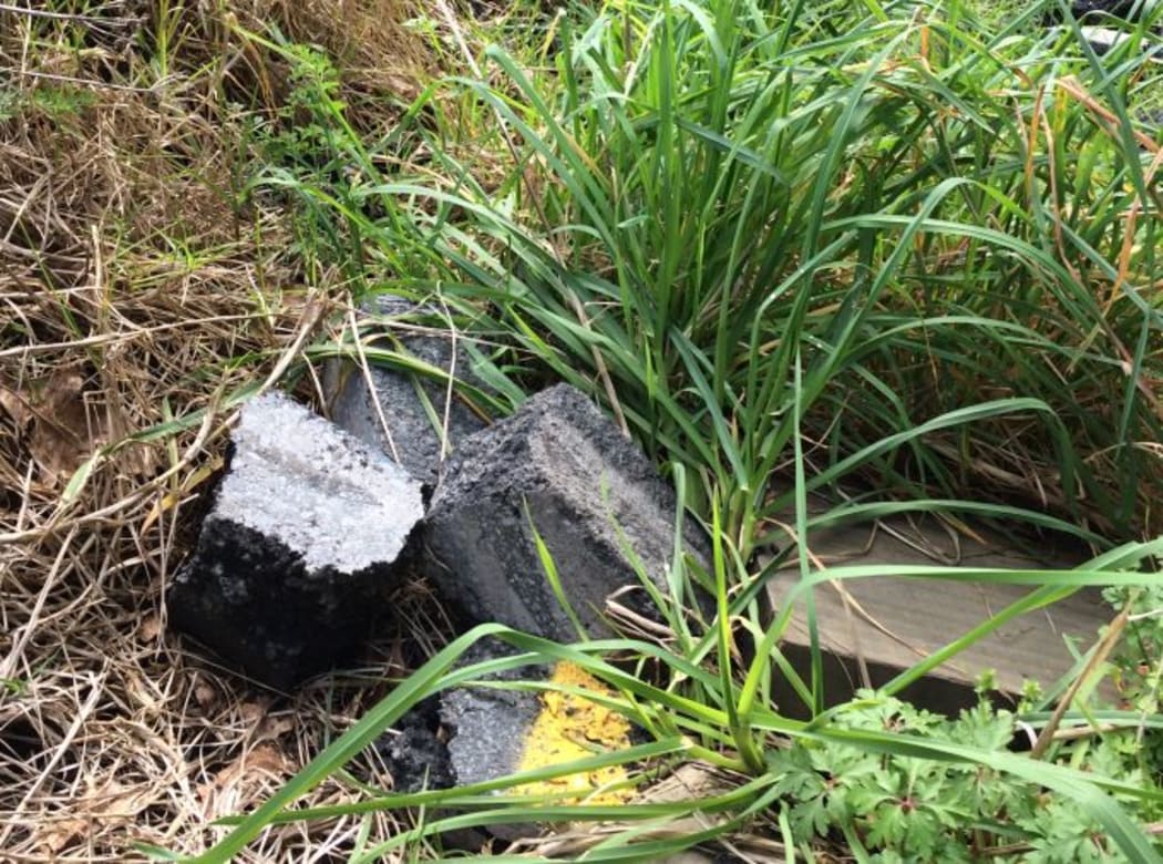 Rubble from road works pictured beside a stream.