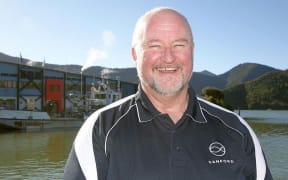 Ted Culley  with plant behind across a bit of sea