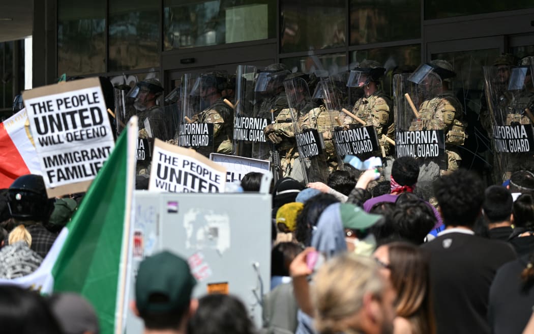 California National Guard members stand guard outside the Federal Building as people gather to protest in response to federal immigration operations in Los Angeles, on June 9, 2025. US President Donald Trump on June 9 ordered active-duty Marines into Los Angeles, vowing those protesting immigration arrests would be "hit harder" than ever. Protests in Los Angeles, home to a large Latino population, broke out on June 6, triggered by immigration raids that resulted in dozens of arrests of what authorities say are illegal migrants and gang members. (Photo by RONALDO SCHEMIDT / AFP)