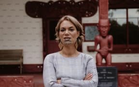 Heeni Hotorene stands with her arms crossed on the forecourt of Te Whare Rūnanga at the historic Waitangi Treaty grounds.