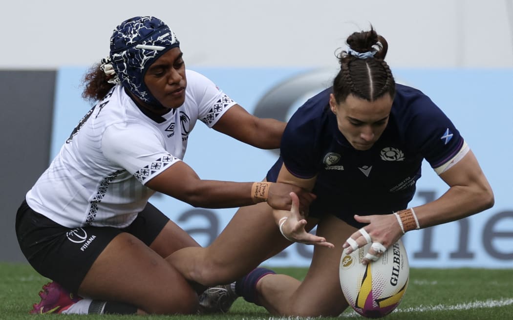 Scotland's wing Francesca McGhie (R) scores a try as Fiji's fly half Salanieta Kinita (L) trys to tackle during the Women’s Rugby World Cup pool B match between Scotland and Fiji at Salford Community Stadium, Manchester, northwest England, on August 30, 2025. (Photo by Adrian Dennis / AFP)