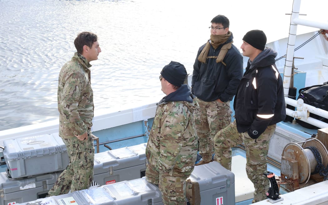 U.S. Military personnel on a fishing boat head the accident site in Yakushima, Kagoshima Prefecture on Dec. 2, 2023. The U.S. Air Force CV-22 Osprey transport aircraft, carrying eight crew members, crashed off the Yakushima Island on Nov. 29, killing at least one person and seven still missing. ( The Yomiuri Shimbun ) (Photo by Tosei Kisanuki / Yomiuri / The Yomiuri Shimbun via AFP)