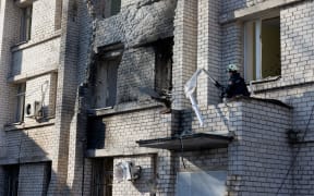 A rescue worker clears debris in a damaged maternity hospital following a Russian strike in Zaporizhzhia on February 1, 2026, amid the Russian invasion of Ukraine. Russian attacks on Ukraine overnight and early on February 1, 2026 killed at least two people and injured seven others, regional authorities said. Among the attacks was a drone strike on a maternity hospital in the southern city of Zaporizhzhia that injured two women undergoing a medical examination, the region's governor and rescuers said. (Photo by Tetiana DZHAFAROVA / AFP)