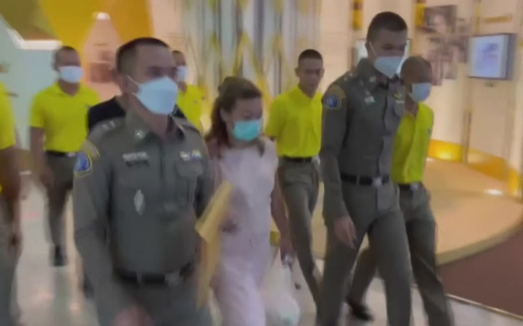 This screen grab taken on April 28, 2023 from handout video footage from Thai PBS via AFPTV shows police escorting suspect Sararat Rangsiwuthaporn (C) from a police station in Bangkok on April 26, 2023. - Thai police have widened their investigation into a woman accused of a spate of cyanide poisoning murders, with officers on April 27 raising the number of victims to 13 and charging her with premeditated murder. (Photo by Handout / various sources / AFP) / RESTRICTED TO EDITORIAL USE - MANDATORY CREDIT "AFP PHOTO / THAI PBS via AFPTV " - NO MARKETING NO ADVERTISING CAMPAIGNS - DISTRIBUTED AS A SERVICE TO CLIENTS - NO ARCHIVE