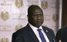First Vice President Riek Machar (L) delivers a speech to journalists next to South Sudan President Salva Kiir (C) and Vice President James Wani Igga (R) prior to the shooting outside the presidential palace in Juba on July 8, 2016.