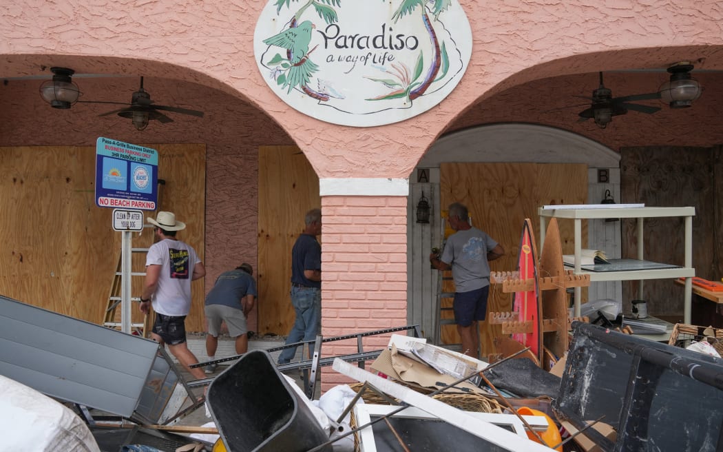 Residents board up a store in the Pass-A-Grille section of St. Petersburg ahead of Hurricane Milton’s expected landfall in the middle of this week in Florida on October 7, 2024. - Florida's governor has declared a state of emergency on Saturday as forecasters warned that Hurricane Milton is expected to make landfall later this week. (Photo by Bryan R. SMITH / AFP)