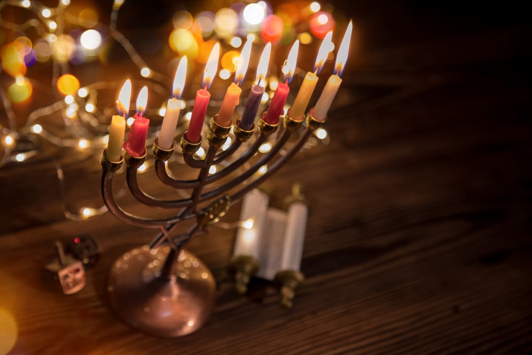 Concept of jewish holiday Hanukkah with menorah (traditional candelabra) and burning candles.