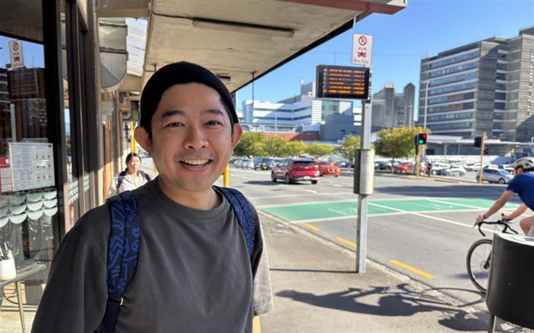John Ng waits for his bus in Wellington.