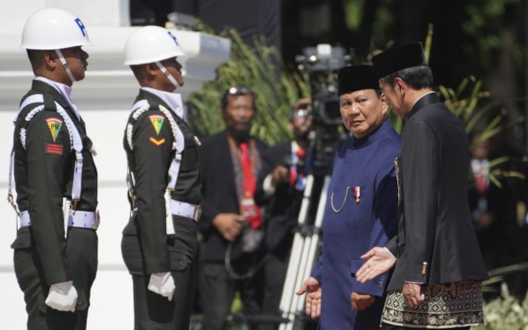 Indonesia's newly-inaugurated President Prabowo Subianto, second right, walks with his predecessor Joko Widodo, right, during their handover ceremony at Merdeka Palace in Jakarta, Indonesia, Oct. 20, 2024.