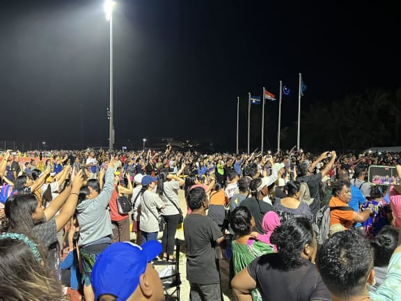 Thousands crowded into the track field for the Micronesian Games opening ceremony, focusing their phone cameras on the lighting of the Games flame by Marshall Islands wrestling star Waylon Muller.