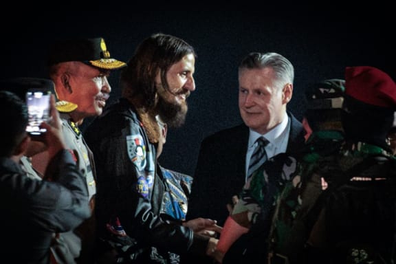 New Zealand pilot Phillip Mehrtens (C), who was snatched by rebels in Indonesia's restive region of Papua in February last year, gestures as he walks with New Zealand Ambassador to Indonesia Kevin Burnett (C, right) after arriving from Central Papua by an air force plane at Halim Perdanakusuma air base in Jakarta on September 21, 2024. Phillip Mehrtens has been released from captivity by rebels in Indonesia's restive Papua region and is in good health despite the 19-month ordeal, Indonesian and New Zealand authorities said on September 21. (Photo by Yasuyoshi CHIBA / AFP)