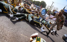 A soldier running past injured comrades lying on the ground at the scene of an attack on a military parade that was marking the anniversary of the outbreak of its devastating 1980-1988 war with Saddam Hussein's Iraq.