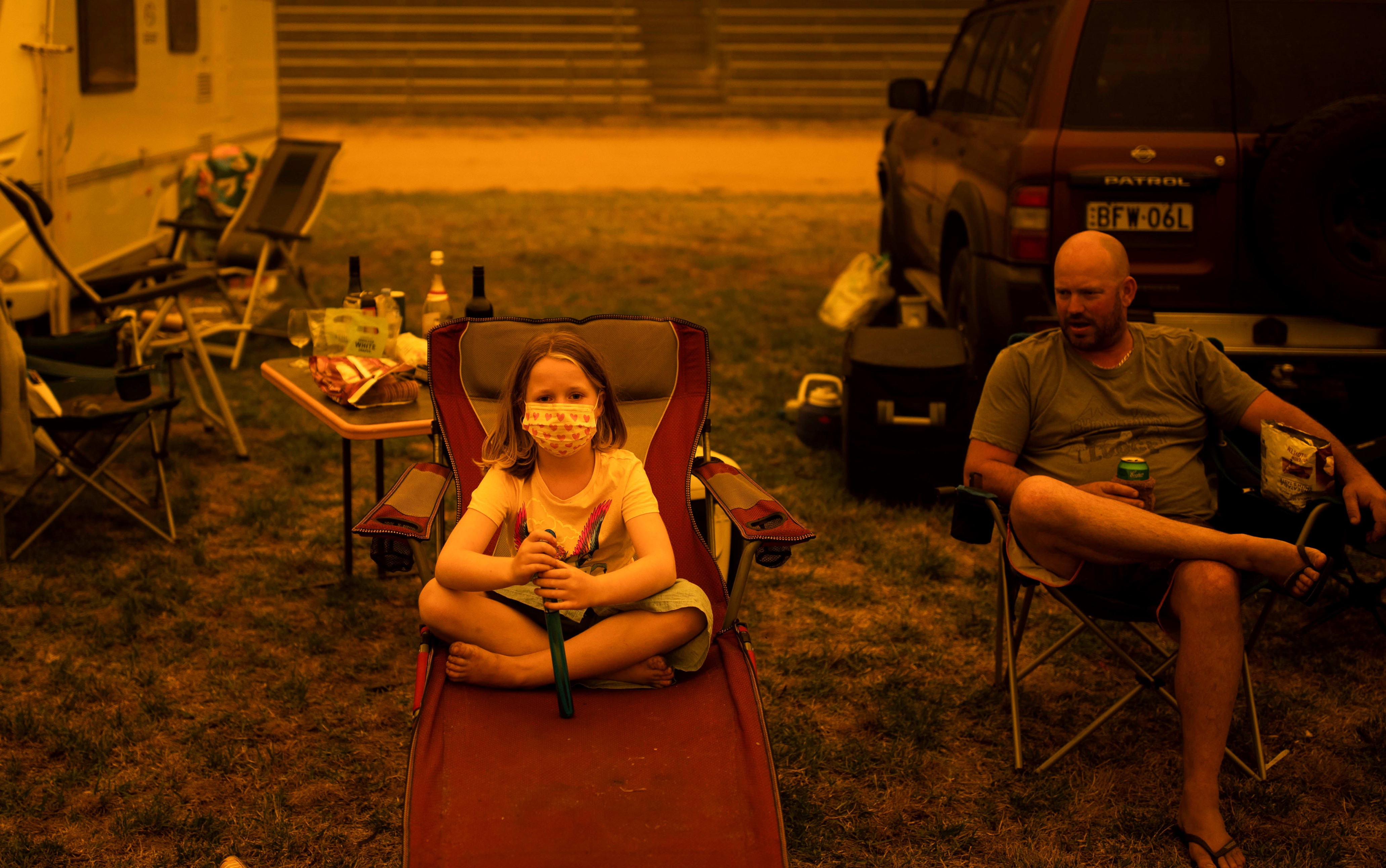 Amy (L) and Ben Spencer sit at the showgrounds in Bega, New South Wales, where they are camping after being evacuated from nearby sites affected by bushfires on December 31, 2019.
