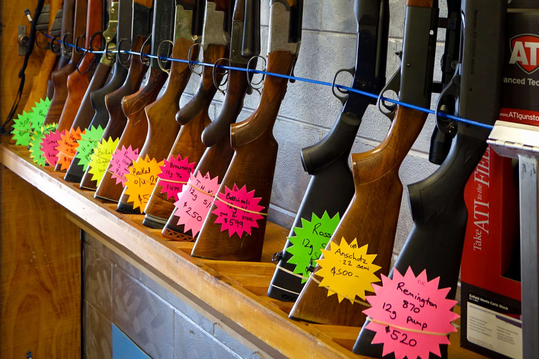 Rifles standing upright in rack with flouro price tags