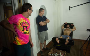 David Farrier (left) inside the strange world of competitive tickling
