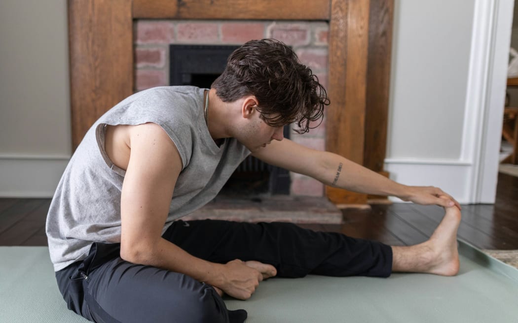 man stretching on yoga mat