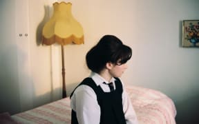 Mary (Maya Le Roux) has a quiet moment of contemplation in her bedroom.