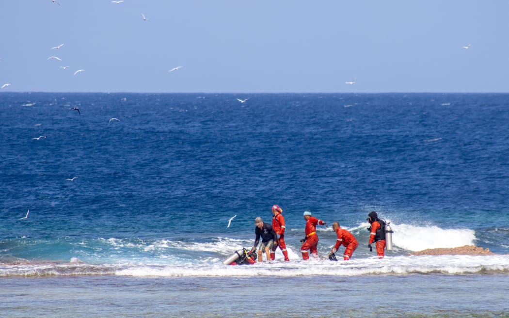 Pulling the cable from the seabed up onto the back reef of Nukunonu