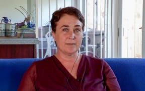 Devora Busch on the couch in her family home.