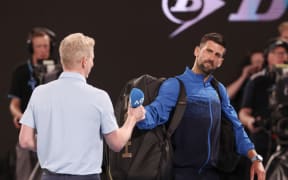 Serbia's Novak Djokovic gives back the microphone after speaking on court after winning his men's singles match against Czech Republic's Jiri Lehecka at the Australian Open.