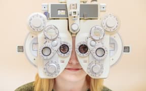 A male ophthalmologist checks a girl's eyesight using a phoropter. Vision treatment.