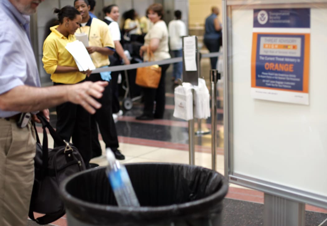 A traveller throws away a water bottle at Regan International Airport in Washington DC as the restrictions come into force in August 2006.