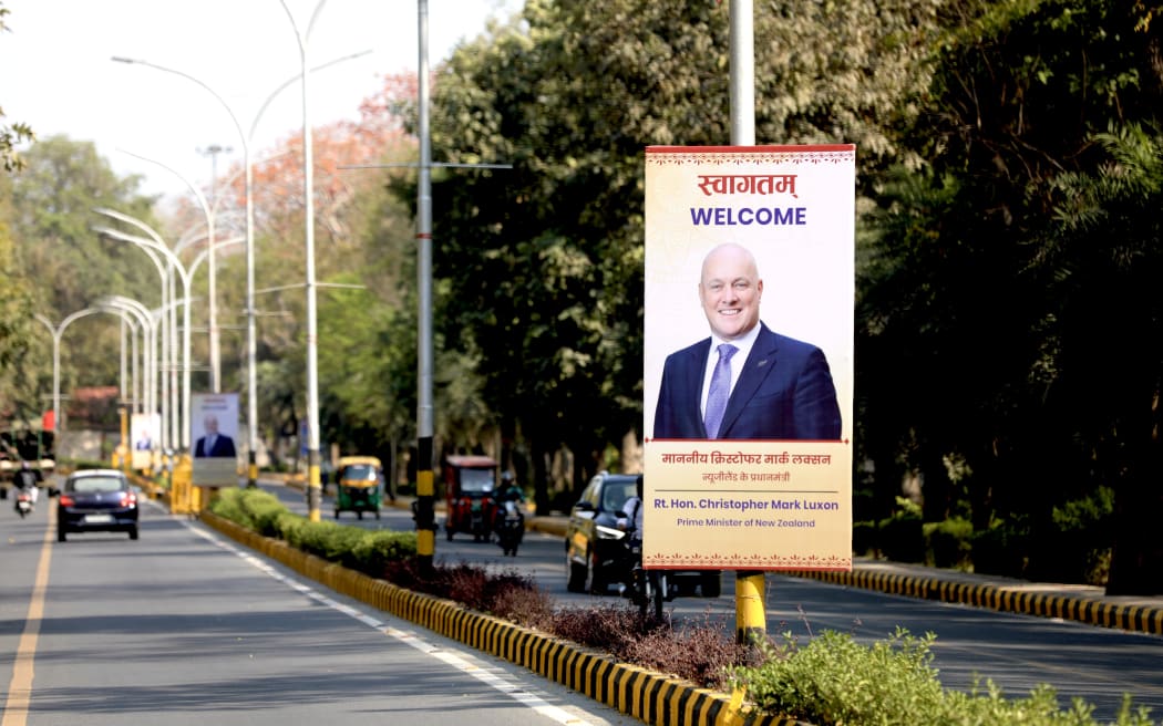 A sign with a picture of Christopher Luxon welcomes the PM to New Delhi.