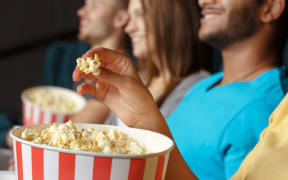 Group of people eating popcorn in the cinema