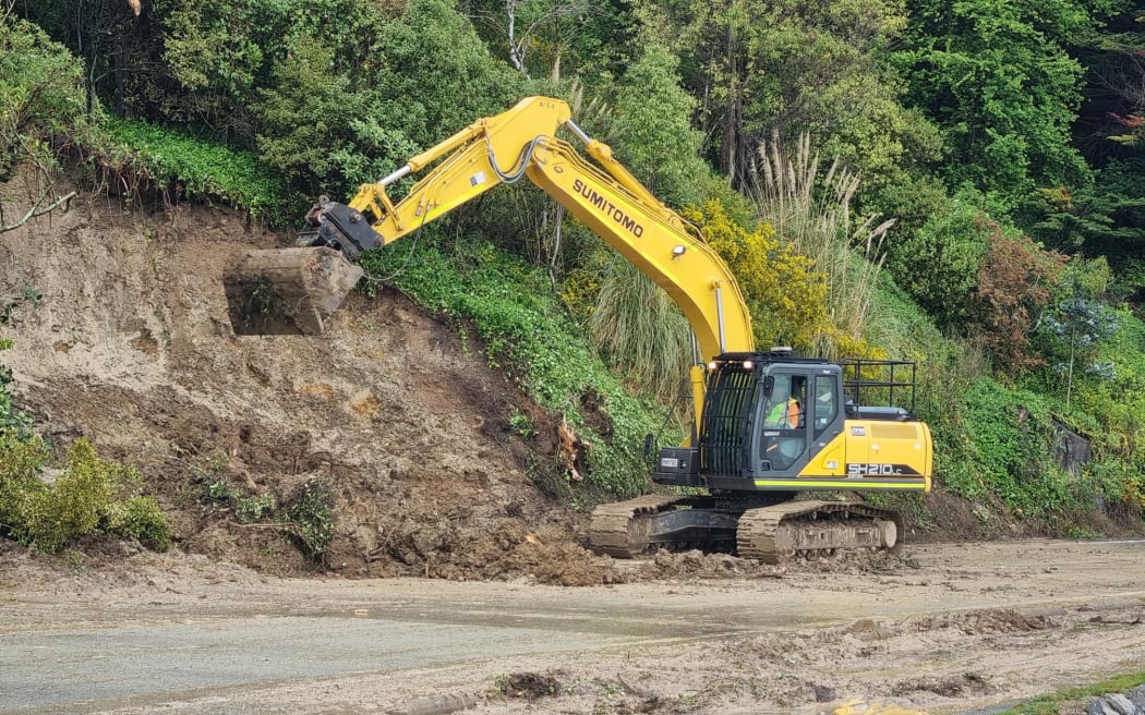A digger clears debris from a slip on Portobello Road.