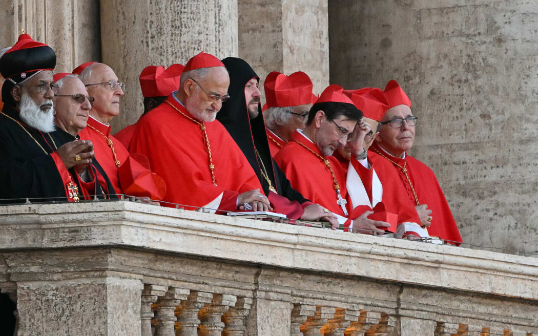 Cardinals react from a balcony of the St Peter's Basilica, as the new pope makes his first appearance after the cardinals ended the conclave, in The Vatican, on May 8, 2025. Robert Francis Prevost was on Thursday elected the first pope from the United States, the Vatican announced. A moderate who was close to Pope Francis and spent years as a missionary in Peru, he becomes the Catholic Church's 267th pontiff, taking the papal name Leo XIV. (Photo by Andrej ISAKOVIC / AFP)