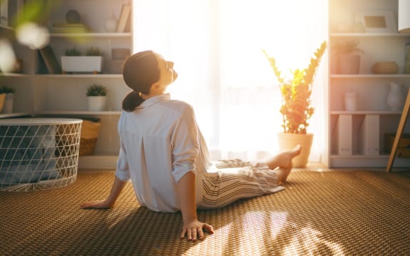 Woman resting near window in sunlight.