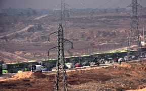 Buses are seen during an evacuation operation of Syrian rebel fighters and civilians from a opposition-held area of Aleppo towards rebel-held territory in the west of Aleppo's province on December 16