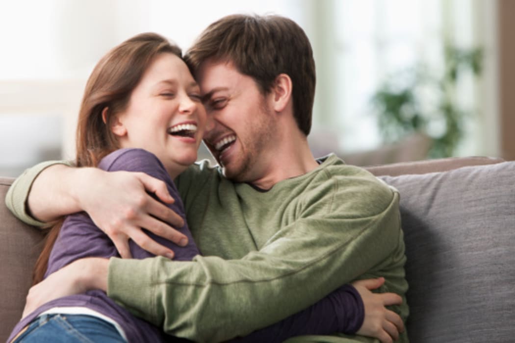 Caucasian couple hugging on sofa