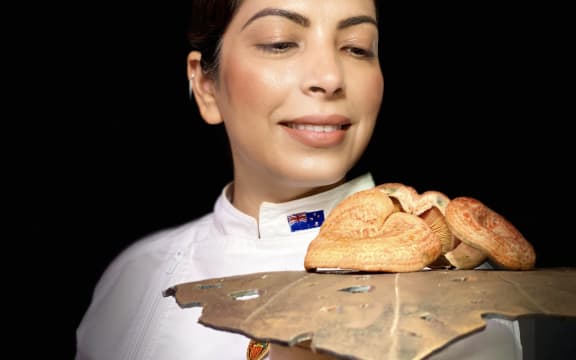 Jasbir Kaur holding up her mushroom caramel with kawakawa custard
