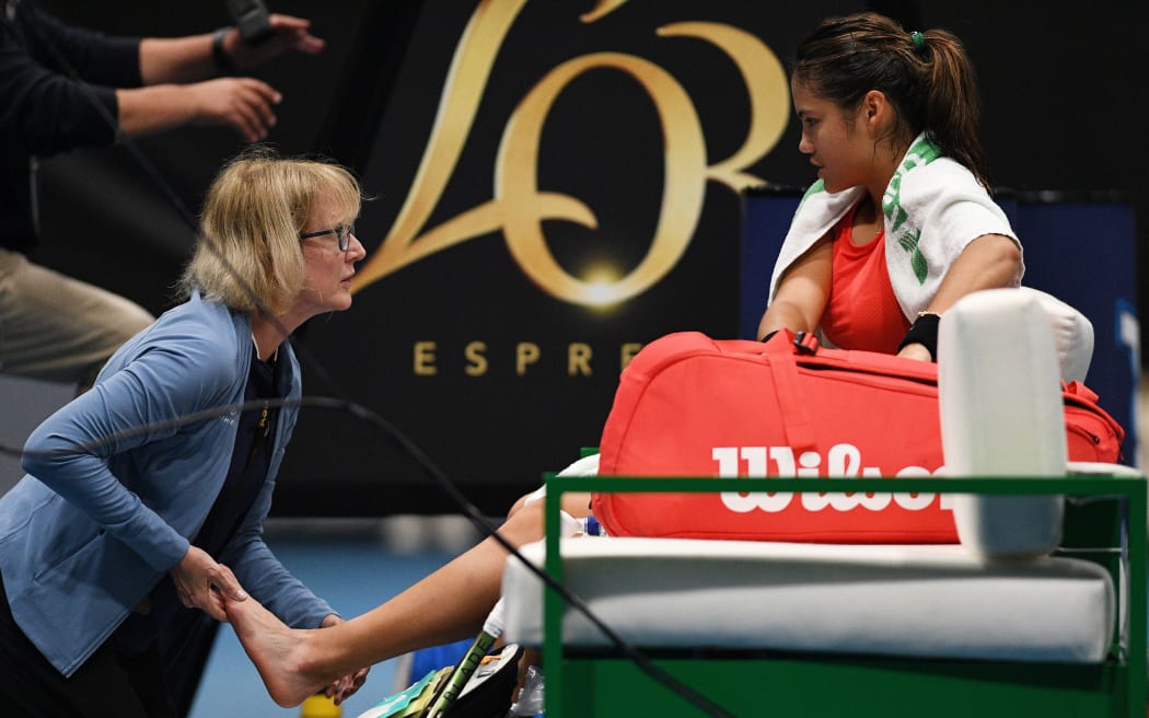 Emma Raducanu of Great Britain receives medical treatment in Auckland 2023.