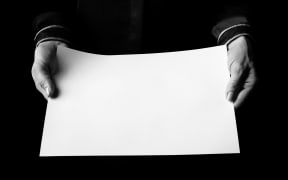 Black Mania. female hands isolated on black showing blank paper sheet