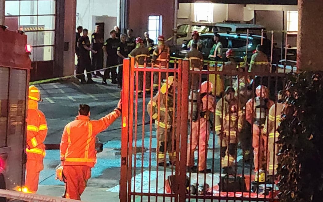 Teams in hazmat gear can be seen outside the Pitt Street fire station following reports of asbestos contamination.