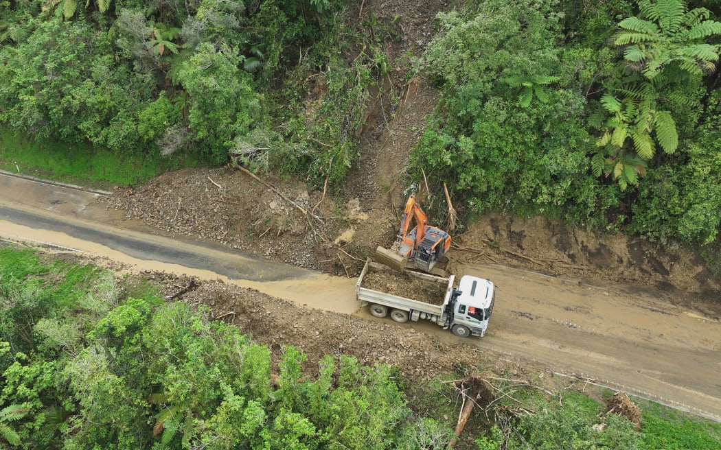 A worker clears a slip on SH3.