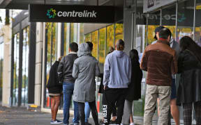 People queue up outside a Centrelink office in Melbourne on April 20, 2020, which delivers a range of government payments and services for retirees, the unemployed, families, carers and parents amongst others. A report from the Grattan Institute predicts between 14 and 26 per cent of Australian workers could be out of work as a direct result of the coronavirus shutdown, and the crisis will have an enduring impact on jobs and the economy for years to come.