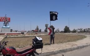 An image grab taken from a video uploaded on 18 May 2015 purportedly shows an IS flag in Ramadi.