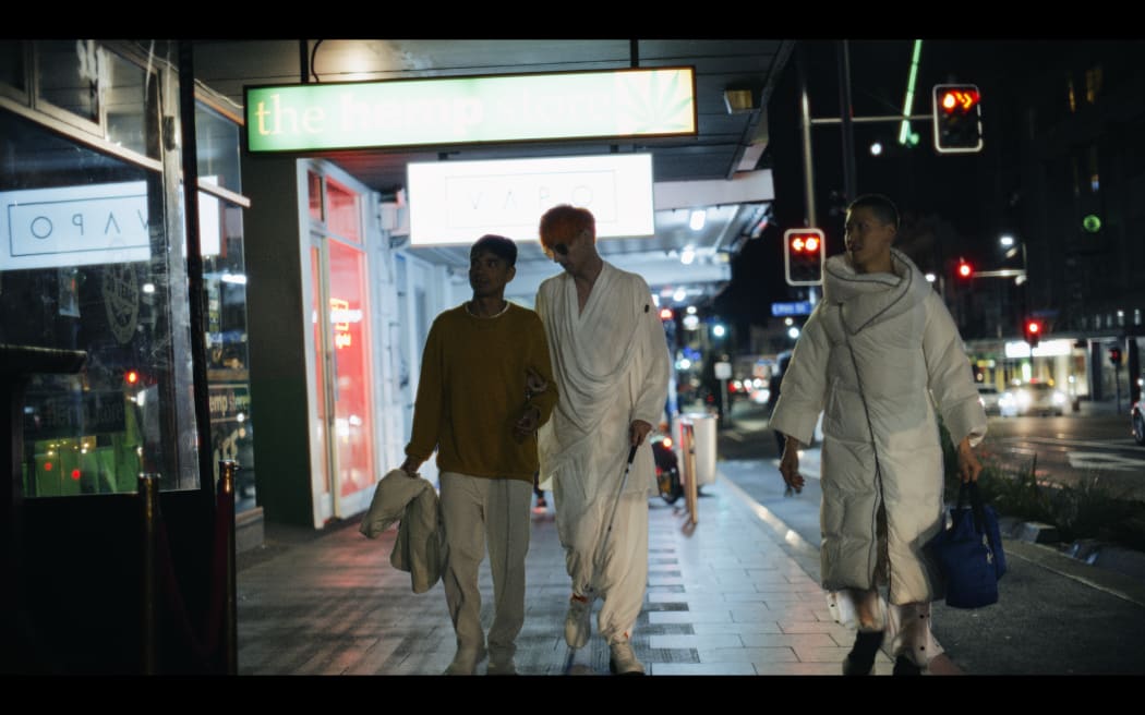 Ari Kressens walks with friends on Karangahape Road