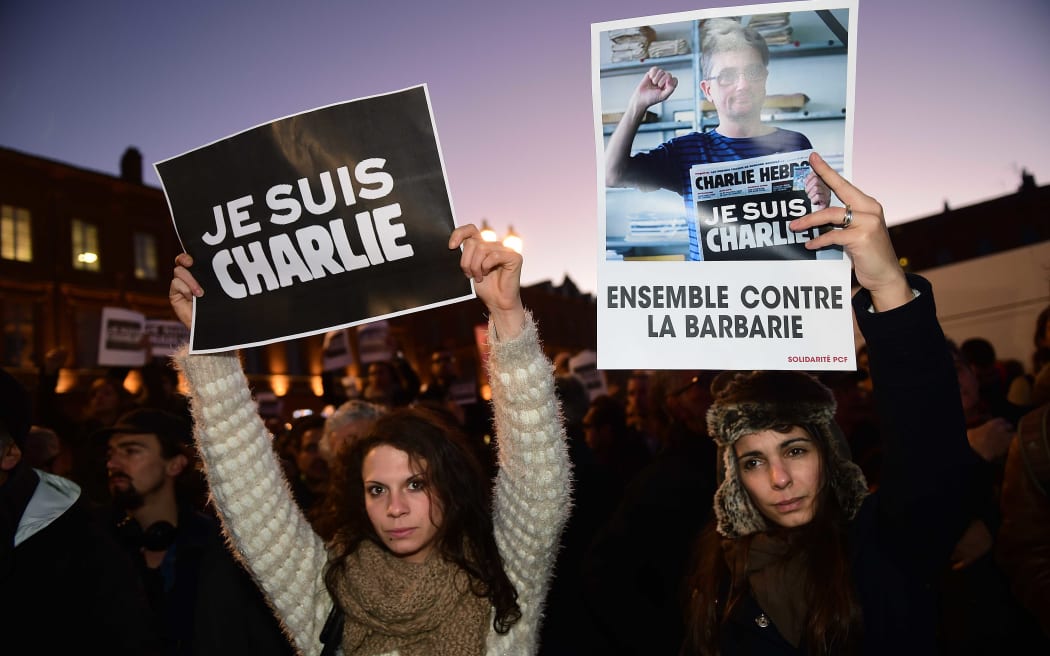 Placards reading "I am Charlie" (L) and "Together against barbarism" during a gathering in Toulouse.